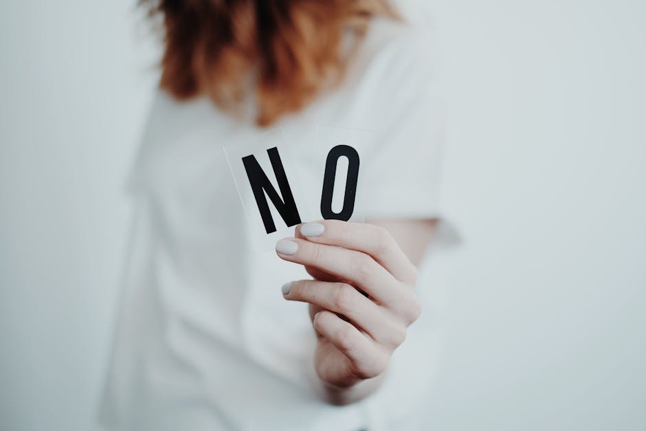 pexels-photo-4439421-4439421 Close-up of a person holding a "No" sign, symbolizing rejection or disagreement.